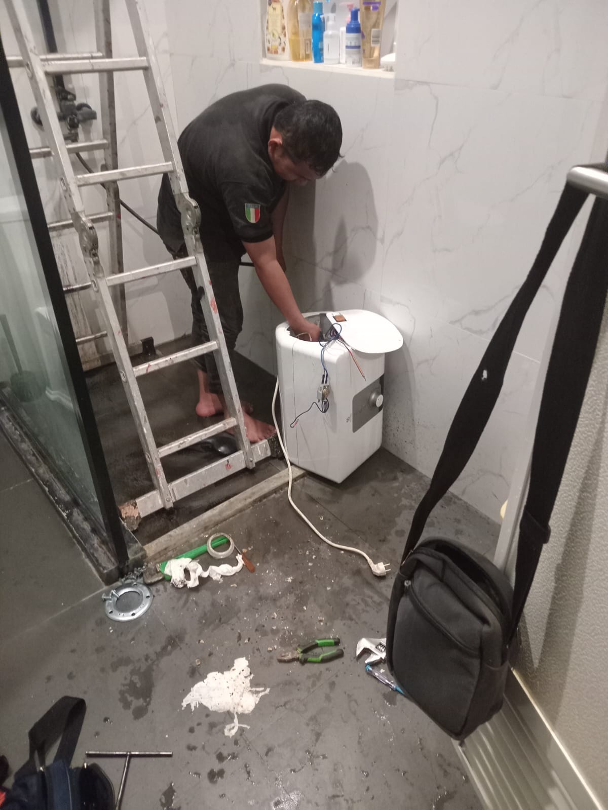 Teknisi spesialis Ariston berseragam resmi memperbaiki water heater di rumah pelanggan